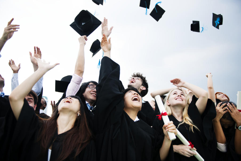 groupe divers diplomes lancant bonnets dans ciel