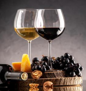 vue face verres vin raisins frais noix fromage jaune planche bois bouteille renversee fond sombre