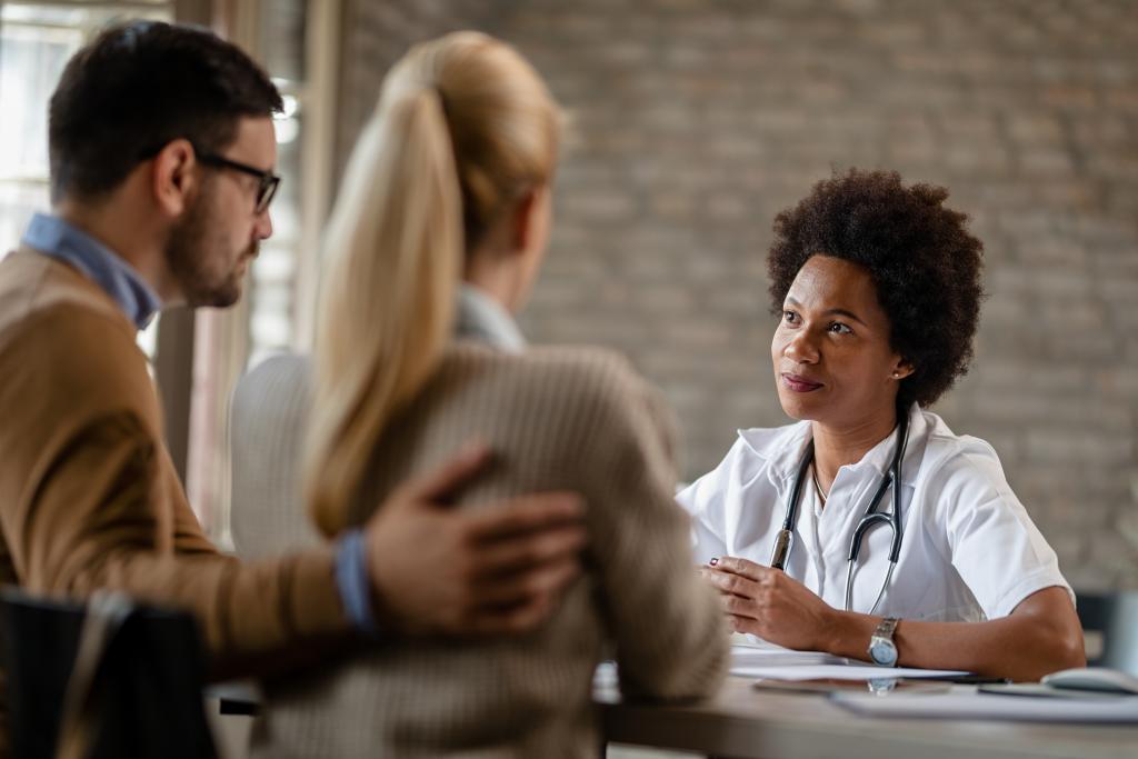 african american general practitioner having consultations with couple medical clinic