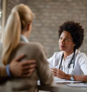 african american general practitioner having consultations with couple medical clinic
