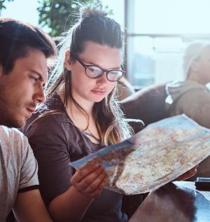 portrait young couple sitting outdoor caf planning itinerary their journey